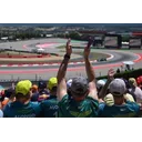 Гонщик Aston Martin на тлі траси