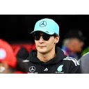Джордж Расселл на тлі боліда Mercedes